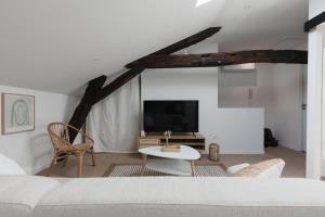 a living room with a bed and a tv at OIQIA • Arthéa • Atelier in Périgueux