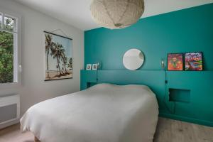 a blue bedroom with a white bed and a blue wall at Maison pour 8 - Piscine chauffée - 100m de la plage in Piriac-sur-Mer +32 photos