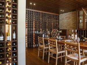 a dining room with a table and a wall of wine bottles at Grecotel LUXME Costa Botanica in Acharavi +72 photos