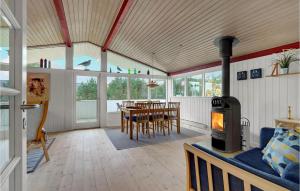 a living room with a table and a wood stove at 4 Bedroom Beautiful Home In Hvide Sande in Hvide Sande