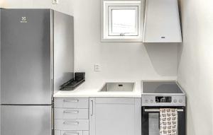 a kitchen with a stainless steel refrigerator and white cabinets at 2 Bedroom Cozy Home In Gotlands Tofta in Västergarn