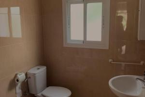 a bathroom with a toilet and a sink and a window at La Casa del Lago in Navas del Rey +24 photos