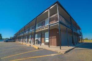 a building with a car parked in a parking lot at Hotel Comfort Stay by OYO Texarkana East, AR I-30 in Whatley