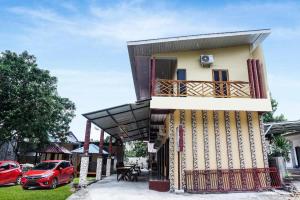 Hotel O Penginapan Dafandra Beach Near Pantai Tanjung Bira في Tabutule: منزل به شرفة وموقفان للسيارات +21 صورة