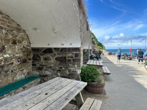 eine Gruppe von Bänken, die neben einer Steinmauer sitzen in der Unterkunft Seacroft - 3 Bed Georgian Listed Townhouse with Wood Burning Stove in Ilfracombe + 28 Fotos