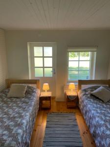 a bedroom with two beds and two windows at Aaviku Holiday Houses in Vanamõisa
