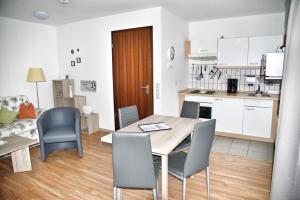 a kitchen and dining room with a table and chairs at Lagunenstadt am Haff Fewo 125 - Yarn in Ueckermünde