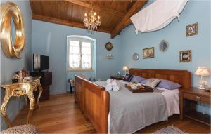 Un dormitorio con una cama con paredes azules y una lámpara de araña. en Stunning Home In Hrboki, en Hrboki