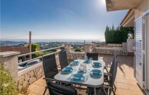 a table with blue dishes on it on a balcony at Gorgeous Home In Sant Cebrià De Vallalt in Sant Cebrià de Vallalta
