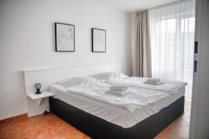 a white bed in a room with a window at Lagunenstadt am Haff Fewo 80 - Kai in Ueckermünde