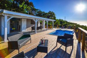 una terraza con sillas y una piscina en Ti sunset et bungalow 2 chambres, en Le Carbet