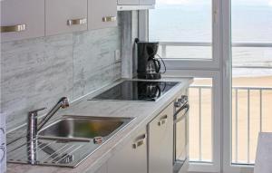 une cuisine avec un évier et une vue sur la plage dans l'établissement Residentie Acapulco 6B, à Ostende