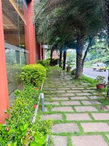 a sidewalk with trees and plants in front of a building at Fortune Hills in Palakkad