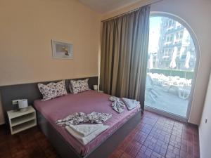 En eller flere senge i et værelse på Rose Garden Omax Apartments + 263 billeder