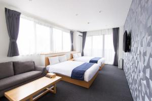 una habitación de hotel con dos camas y un sofá en Neo Field Nakasu, en Fukuoka
