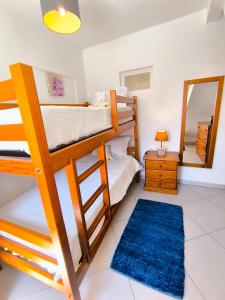 Un dormitorio con dos literas y un espejo. en Sweet Home Casa Melita 1º Piso, en Ferragudo