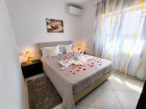 Un dormitorio con una cama con una flor. en Sweet Home Casa Melita 1º Piso, en Ferragudo
