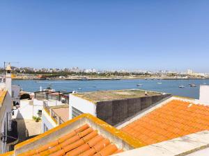 Una vista del agua desde los tejados de los edificios. en Sweet Home Casa Melita 1º Piso, en Ferragudo