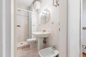 a white bathroom with a sink and a toilet at Ponte Vecchio Comfort Apartment in Florence