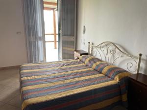 a bed with a colorful blanket on it in a room at Quietovivere in Lido di Spina