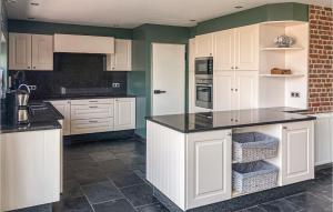 a kitchen with white cabinets and a black counter top at Landweg in Tielt