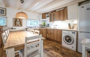 a kitchen with a table and a washing machine at 1 Bedroom Stunning Home In Laag-Soeren in Laag-Soeren