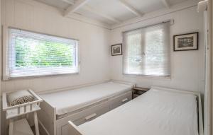 a white room with a bench and two windows at 1 Bedroom Stunning Home In Laag-Soeren in Laag-Soeren