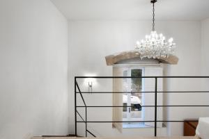 a chandelier in a living room with a white wall at Hotel Palazzo Cavalieri in Syracuse