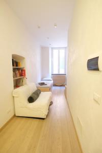 un soggiorno con sedia bianca e divano di Nonna Nanda Nest by PortofinoVacanze a Rapallo