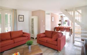 a living room with two red couches and a table at Tulp En Zee 6 Persoons in Noordwijk aan Zee