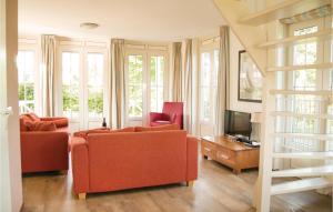 a living room with two orange couches and a television at Tulp En Zee 6 Persoons in Noordwijk aan Zee