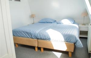 a bedroom with a bed with blue sheets and blue pillows at Tulp En Zee 6 Persoons in Noordwijk aan Zee +6 photos