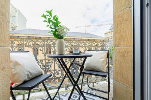 stół z 2 krzesłami i waza na balkonie w obiekcie San Sebastian City Center⎮3 Bedrooms⎮Free WIFI w mieście San Sebastián
