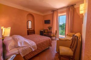 pokój hotelowy z łóżkiem i oknem w obiekcie Villa Romita w mieście SantʼAgata sui Due Golfi