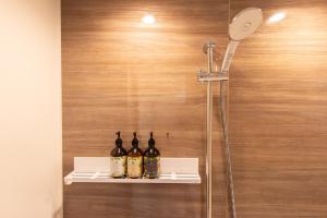 tres botellas de vino sentadas en un estante en una ducha en Neo Field Nakasu, en Fukuoka 46 fotos más