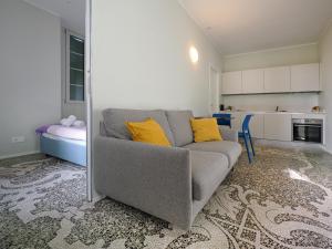 a living room with a gray couch and yellow pillows at Appartamenti Music 2 - Light and Shadows 3 - Estival 4 - Blues 5 in Muralto