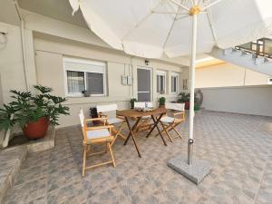 eine Terrasse mit Tisch, Stühlen und Sonnenschirm in der Unterkunft Ntina's Apartment in Rhodos (Stadt)