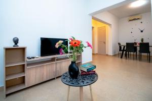ein Wohnzimmer mit einer Vase mit Blumen auf dem Tisch in der Unterkunft Ntina's Apartment in Rhodos (Stadt)