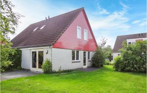 a red and white house with a yard at Oesterbaai -5C1 in Wemeldinge