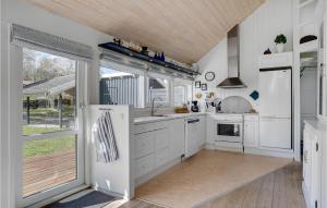 a kitchen with white cabinets and a wooden ceiling at Holiday Home Lyngsbækvej Ix in Ebeltoft