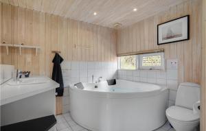 a bathroom with a large tub and a toilet at Holiday Home Lyngsbækvej Ix in Ebeltoft