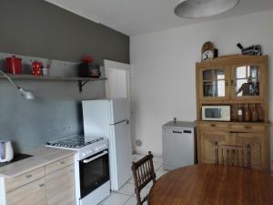 a kitchen with a white refrigerator and a table at La Slow Life in Saint-Maurice-sous-les-Côtes