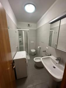 ein Badezimmer mit Waschbecken, Toilette und Spiegel in der Unterkunft Residence Armor - Agenzia Cocal in Caorle + 5 Fotos