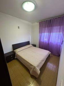 ein Schlafzimmer mit einem Bett und einem lila Vorhang in der Unterkunft Residence Armor - Agenzia Cocal in Caorle