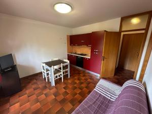 ein Wohnzimmer mit Tisch und Küche in der Unterkunft Residence Armor - Agenzia Cocal in Caorle