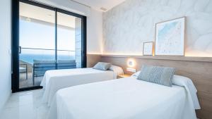 two beds in a room with a view of the ocean at Benidorm Beach, Grupo AMI in Benidorm +44 photos