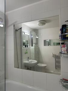 a white bathroom with a sink and a mirror at Alexandra Palace White Hart Lane Twin room in London