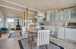 a kitchen and dining room with a table and chairs at Holiday Home Ebeltoft 18 in Ebeltoft