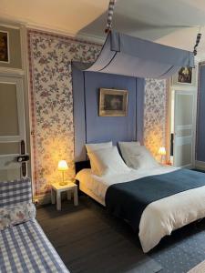 a bedroom with a bed with a blue head board at Château de Goville in Le Breuil-en-Bessin