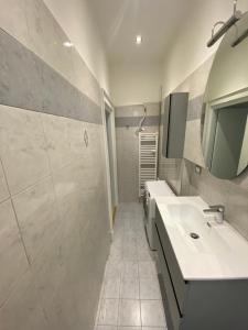 a white bathroom with a sink and a mirror at Brera's Elite Apartment in Milan +12 photos